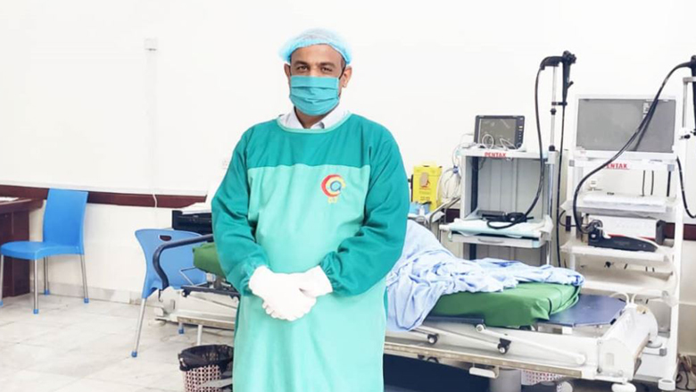  احد العاملين الصحيين في مستشفي باليمن مرتديا قناع الوجه الواقي في ظل انتشار جائحة كورونا 