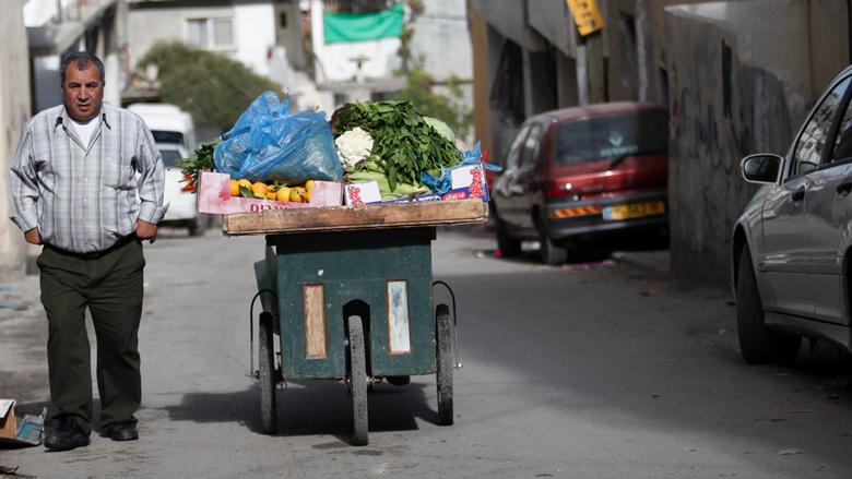 بائع خضروات من الضفة الغربية بالأراضي الفلسطينية يعاني صعوبة بيع بضاعته.
