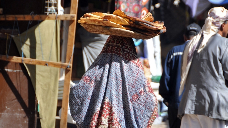 امرأة بالزي التقليدي تحمل الخبز فوق رأسها. صنعاء، اليمن. تصوير: فؤاد الحرازي / البنك الدولي